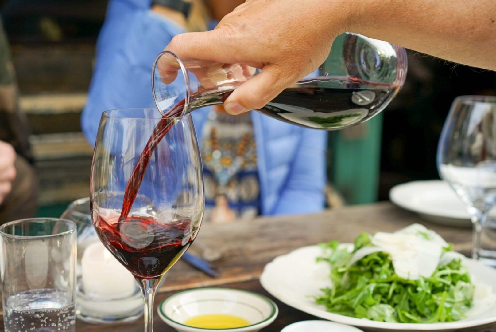 Person Pouring Red Wine on Wine Glass